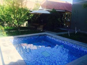 a swimming pool with blue water in a yard at Argavand Hotel & Restaurant Complex in Argavand