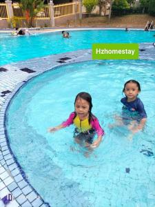 two children are swimming in a swimming pool at Ocean view resort homestay near beach free wifi,cucckoo 3ROOM in Port Dickson