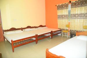 a bedroom with two beds in a room at Hotel Prasanna in Trincomalee