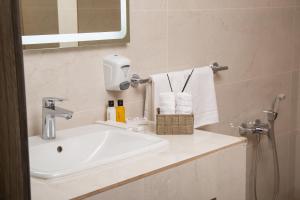 a bathroom with a sink and towels on a counter at Rasoda Hotel&Restaurant in Tashkent