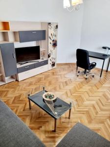 uma sala de estar com uma mesa e uma cadeira em Cozy apartment near city center em Bucareste