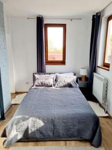 um quarto com uma cama com um edredão azul e uma janela em Cozy apartment near city center em Bucareste