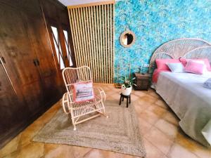 sypialnia z fotelem bujanym i łóżkiem w obiekcie GATU PREMIUM Villa Lurberri piscina privada, 4 dormitorios, 2 baños, parking , jardines, " Preferente mayores de 25 años y familias " ín y barbacoa w mieście Chiclana de la Frontera