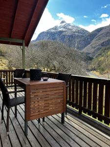 a table on a deck with a view of a mountain at Gjørven Hytter in Flåm