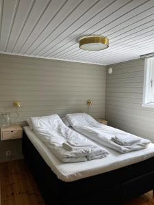 a large bed in a room with a ceiling at Gjørven Hytter in Flåm