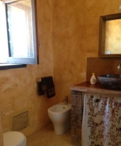 bagno con servizi igienici, lavandino e specchio di Pantelleria 4 passi dal mare a Pantelleria
