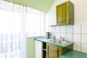 a small kitchen with a sink and a window at Villa & Domek Maja in Sarbinowo