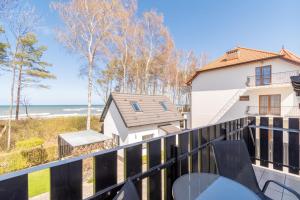 a balcony with a view of the ocean at Villa & Domek Maja in Sarbinowo