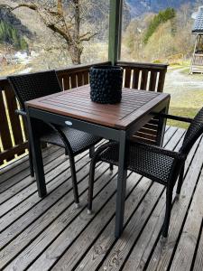 a wooden table and two chairs on a deck at Gjørven Hytter in Flåm +33 photos