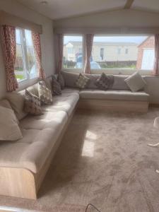 a large couch in a living room with windows at 185 Holiday Resort Unity in Berrow