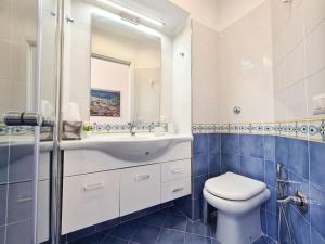 uma casa de banho com um WC, um lavatório e um espelho. em Casetta Mirella em Capri