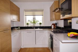 a kitchen with white cabinets and a bowl of fruit on the counter at East Rd in London