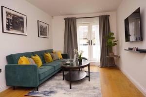 a living room with a green couch and a table at East Rd in London