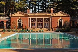 a house with a swimming pool in front of a building at Gideon Putnam Resort & Spa in Saratoga Springs