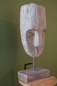 a wooden mask on top of a wooden table at Hôtel Restaurant Le Fiacre à Quend plage in Quend