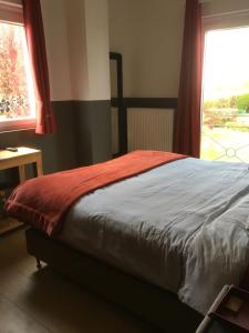 A bed or beds in a room at Maison et son jardin situés dans le Condroz