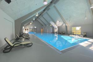 a large swimming pool with chairs in a building at Vineta Ferienpark Usedom in Ostseebad Koserow