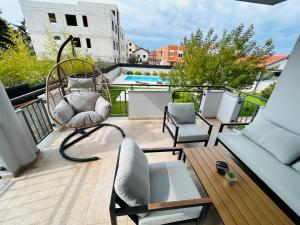 een balkon met een rotan stoel en een schommel bij Apartments Angelo in Bibinje