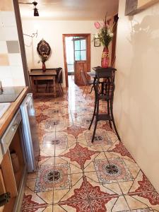 a kitchen with a tile floor with a table and chairs at Chambres d'hôtes - la Puysæ in Saint-Sauveur-en-Puisaye