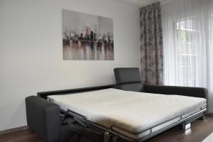 a bed sitting in a room next to a window at Tabáň Halifax apartment - city center & free parking in Nitra