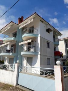 - un bâtiment blanc avec des balcons sur le côté dans l'établissement Dominikis appartment, à Néa Péramos
