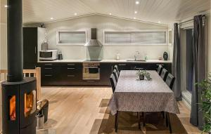 uma cozinha com uma mesa com cadeiras e um fogão em Lovely Home In seral With House A Mountain View em Åseral