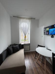 - un salon avec un canapé, une table et une fenêtre dans l'établissement ApartmentsByMatyrafa-II, à Tarnowskie Góry