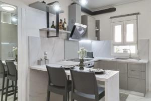 cocina blanca con mesa, sillas y encimera en Modern Studio for Two, Mytilene Lesvos, en Mytilini