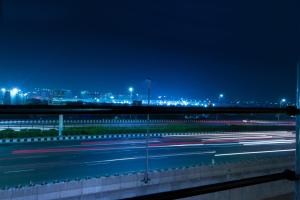 Vista nocturna de una autopista con coches en OPO Essential SKYNEX AEROCITY,Free airport Pickup and Drop, en Nueva Delhi