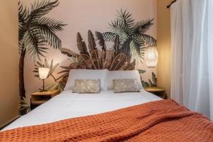 a bedroom with a white bed with palm trees on the wall at Duplex Oscar Freire in São Paulo