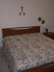 een slaapkamer met een bed met een kruis aan de muur bij Casa vacanza spiaggia Praia in Favignana