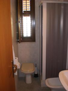 een badkamer met een toilet, een wastafel en een raam bij Casa vacanza spiaggia Praia in Favignana