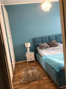 Dormitorio azul con cama y mesita de noche en Niebieski klimat apartament 40m2, en Pruszcz Gdański