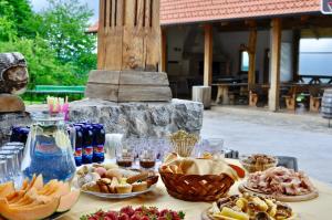 Guest house Domačija Krnc في Hrib pri Hinjah: طاولة مليئة بأطباق الطعام والمشروبات
