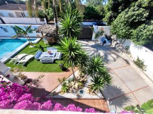 z widokiem na ogród z palmami i basenem w obiekcie GATU PREMIUM Villa Lurberri piscina privada, 4 dormitorios, 2 baños, parking , jardines, " Preferente mayores de 25 años y familias " ín y barbacoa w mieście Chiclana de la Frontera