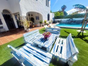 grupa niebieskich ławek siedzących na podwórku w obiekcie GATU PREMIUM Villa Lurberri piscina privada, 4 dormitorios, 2 baños, parking , jardines, " Preferente mayores de 25 años y familias " ín y barbacoa w mieście Chiclana de la Frontera +37 zdjęć