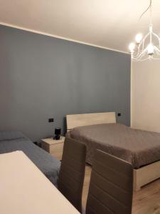 a bedroom with two beds and a table and chairs at Appartamenti con 1 e 2 camere Caldiero in Caldiero