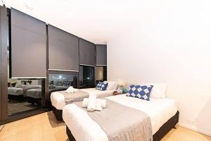 Una habitación de hotel con dos camas y un espejo. en Bright Urban Oasis, en Melbourne