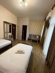 um quarto de hotel com duas camas e um sofá em NAREMA FAMILY HOTEL MEGHRI em Meghri