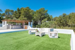 un cortile con un prato arredato e un gazebo di Villa Horizonte - Eivillas Ibiza a Port des Torrent