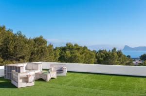 un cortile con un prato arredato di Villa Horizonte - Eivillas Ibiza a Port des Torrent
