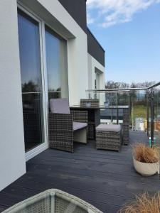 a balcony with wicker chairs and a table at Nadmorski Apartament in Gąski