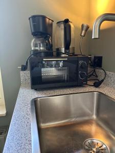 a toaster oven sitting on a counter next to a sink at Rembrandthuis in Ommen