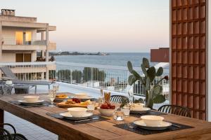 una mesa de madera con comida en la parte superior de un balcón en Sea View Beach Penthouse - Athens Coast en Atenas