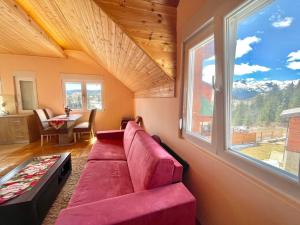 a living room with a red couch and a window at Family Two-bedroom apartment Zabljak in Žabljak