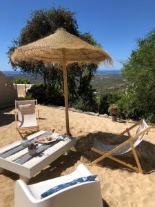 zwei Stühle und ein Sonnenschirm am Strand in der Unterkunft Felicidade in Loulé