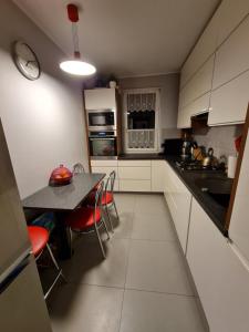 cocina con armarios blancos, mesa y sillas en Ines Apartament en Ostrów Wielkopolski