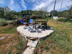 una mesa y sillas sentadas en un patio de piedra en TinyHouse Rossas, en Santa Comba de Rossas