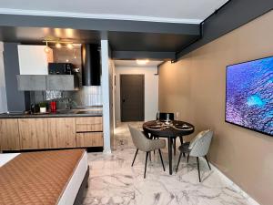 a kitchen and a dining room with a table and chairs at Blue Luxury Studio in Mamaia