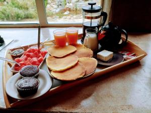 ein Tablett mit Pfannkuchen und Getränken auf dem Tisch in der Unterkunft La Cera Farm Camping B&B in Santa Teresa Gallura